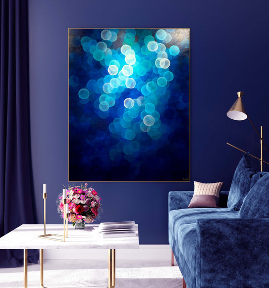 Aqueous Ascending is a large original artwork with calming blue tones and floating orbs. Artwork in designer living room with blue couch and wall. Marble coffee table.