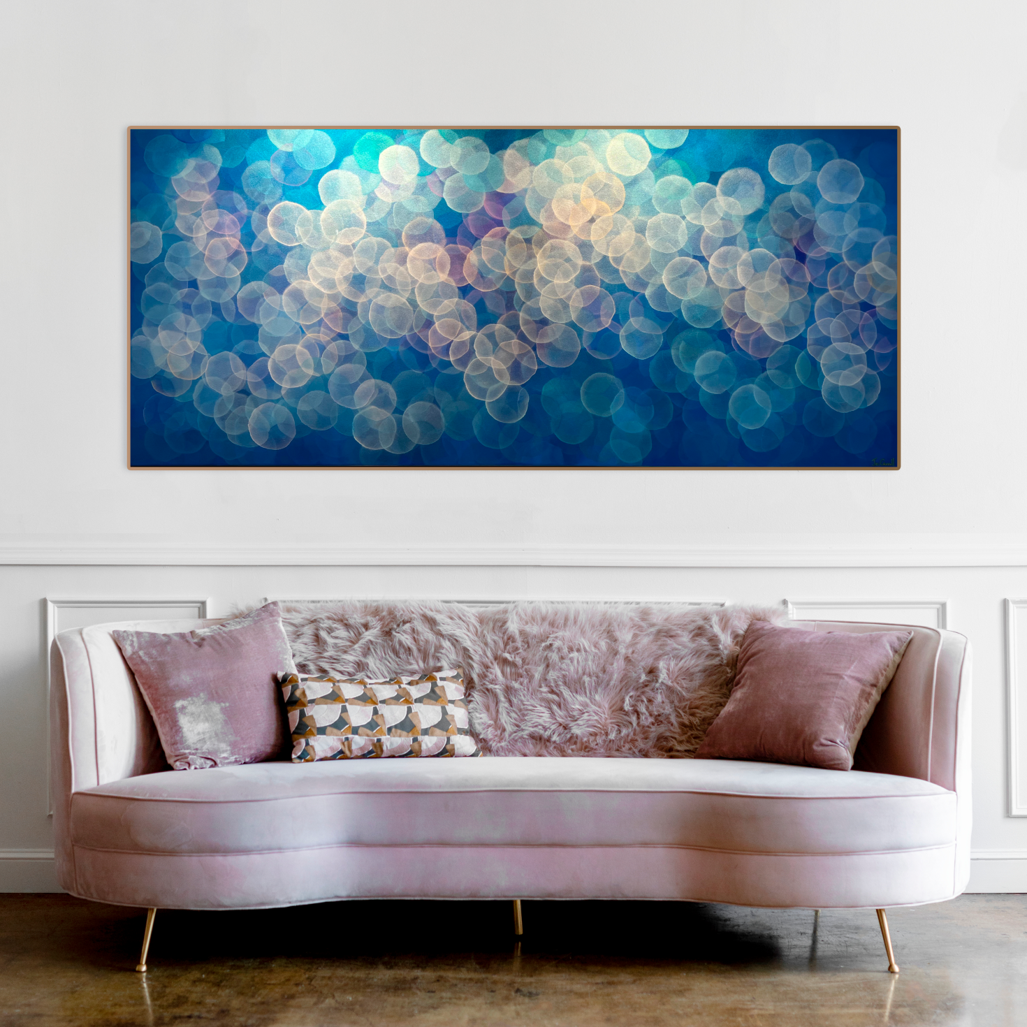 The colour palette is subtle yet captivating, with delicate pastel tones blending seamlessly together. Soft shades of lavender, blush pink, and sky blue imbue the artwork with a sense of warmth and comfort, while hints of gold add a touch of luminosity and depth. Original art by Australian abstract artist Jo Carroll. Art above pink retro couch.